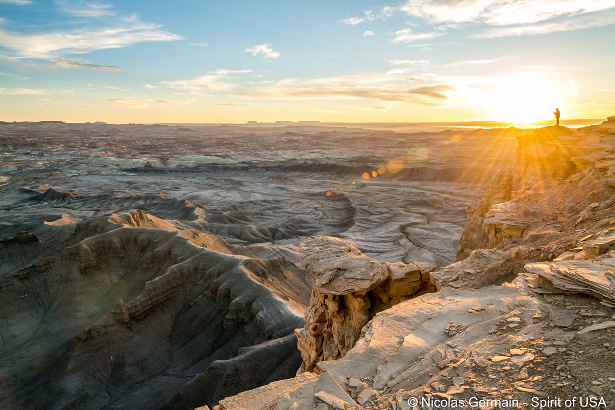 Un photographe au bord de la falaise à Moonscape Overlook au lever du soleil, Utah